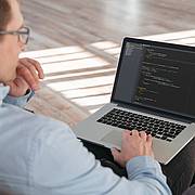 Mann arbeitet am Laptop