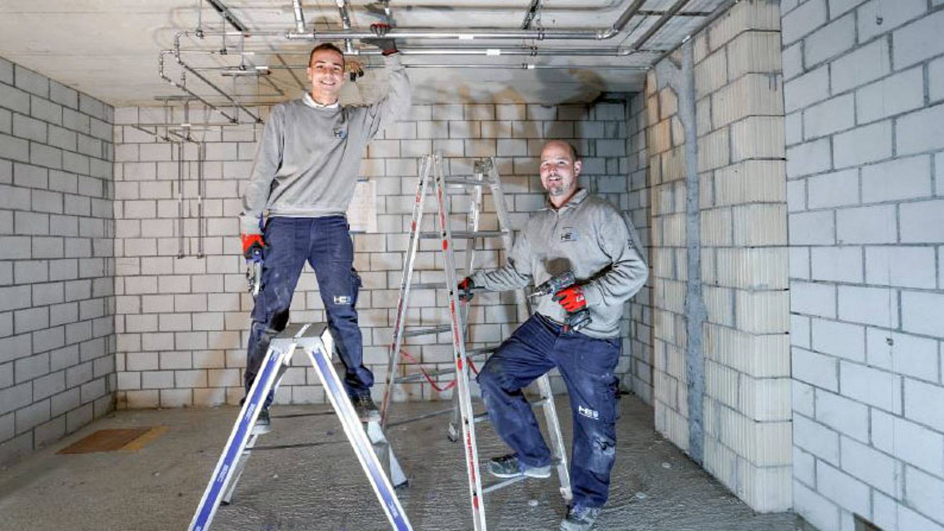 Zwei Mitarbeiter von Gebert stehen vor der fertigen Montage einer Installation