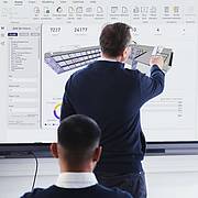 Dozent zeigt an einer virtuellen Wandtafel ein Modell