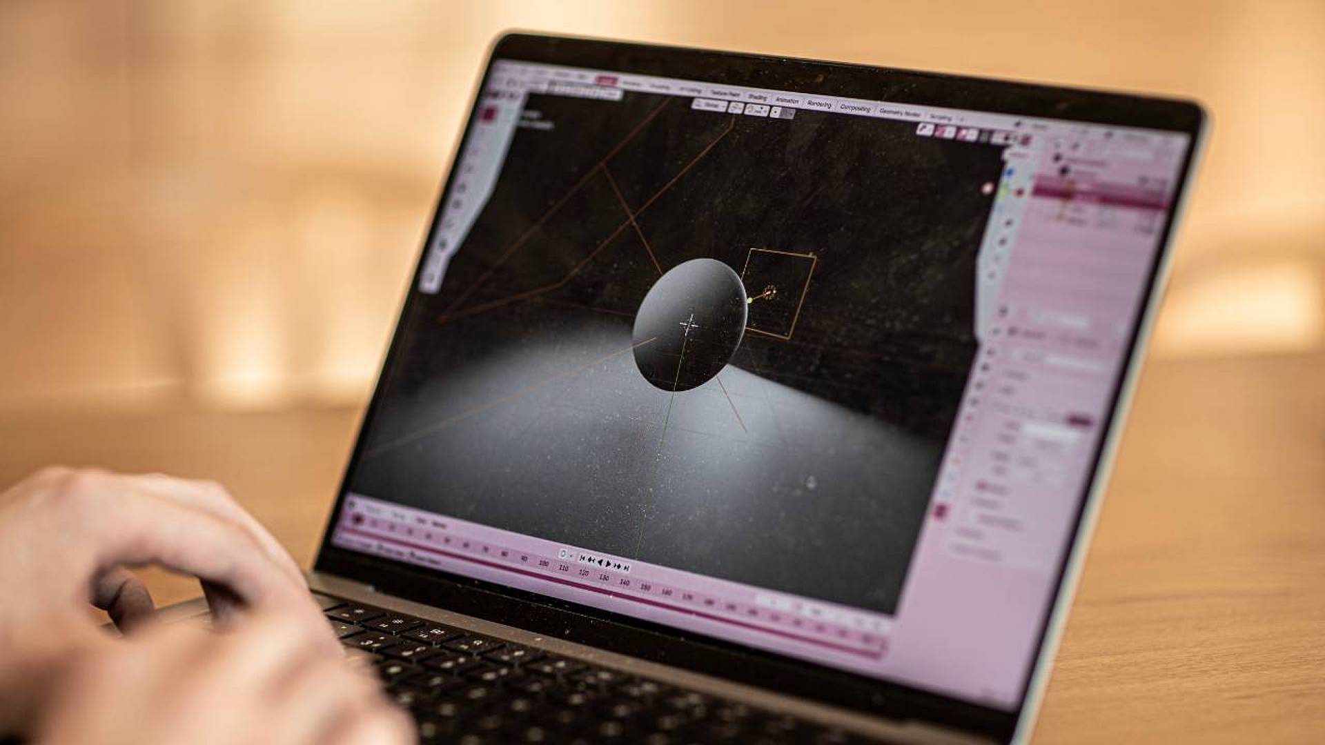 Blender‑Szene auf einem Laptop mit einer schwebenden Kugel, ausgeleuchtet mit Lichtquelle und sichtbarem 3D‑Koordinatensystem.