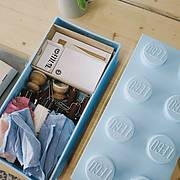 Materialbox für Lego‑Print mit Druckwerkzeugen, Papier, Farben und einem grossen Lego‑Stein als Deckel.